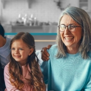 younger grandparents sitting on a couch with a young couple and their little girl