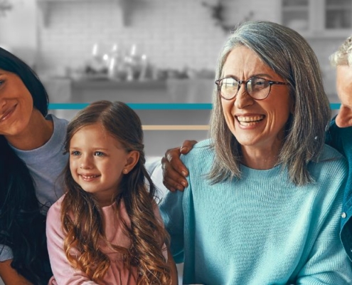 younger grandparents sitting on a couch with a young couple and their little girl