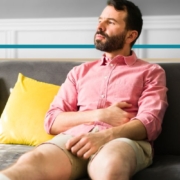 a man with a leg in a cast sitting on a couch looking out the window