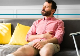 a man with a leg in a cast sitting on a couch looking out the window