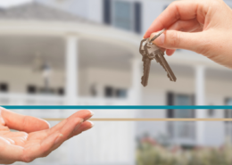 hands exchanging keys to a home in the background