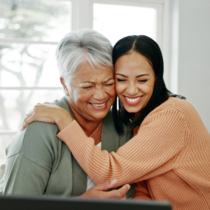 an adult woman hugging her mother, they are smiling