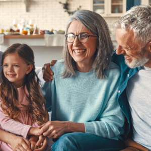 a child, grandmother and grandfather sitting together laughing