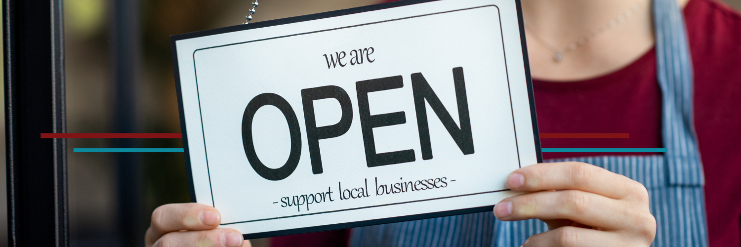 nov-banner-small-biz-sat female business owner flipping a store open sign that says support local business