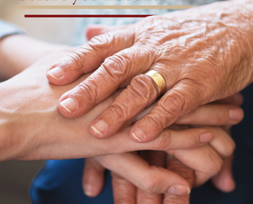 older gentleman's hand with wedding ring holding someone's hand in comfort