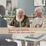 elderly couple in an office with an attorney signing an agreement