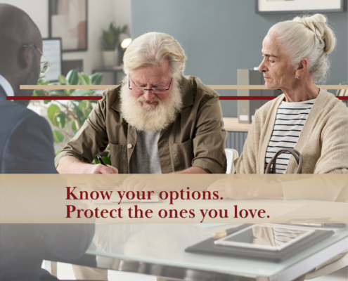elderly couple in an office with an attorney signing an agreement
