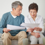 middle aged asian couple reviewing documents at home