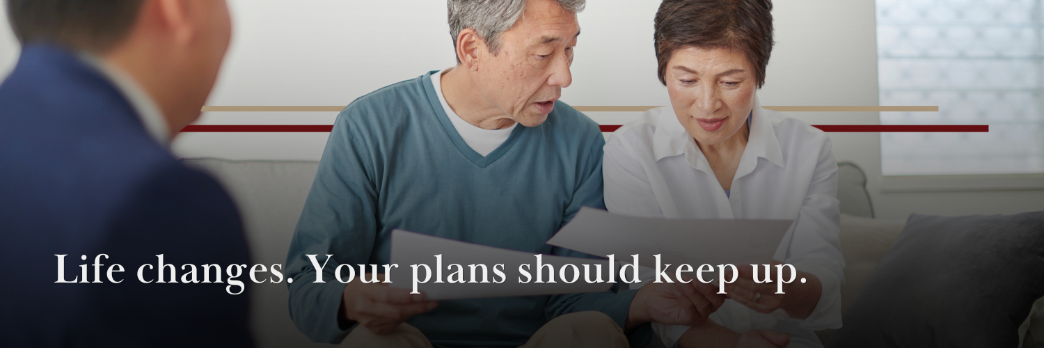 middle aged asian couple reviewing documents at home